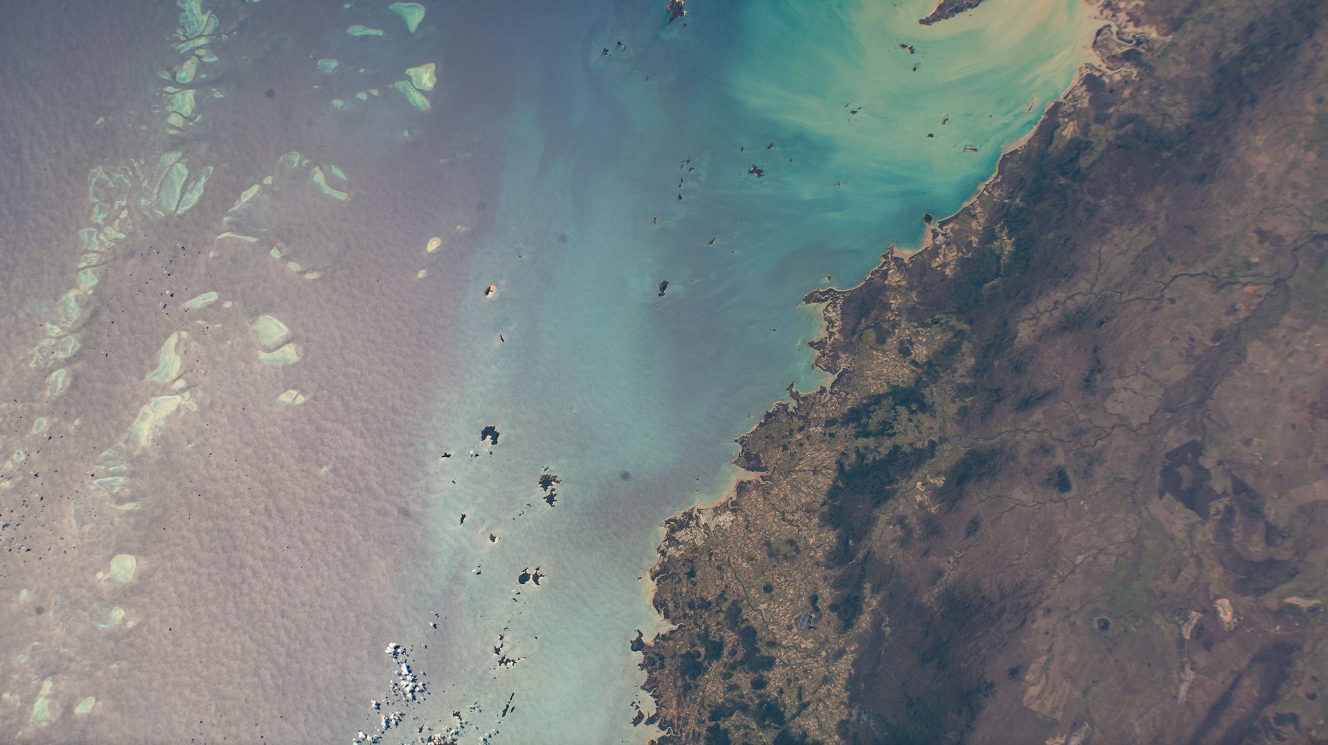 Reefs of the Great Barrier Reef off the coast of Queensland, Australia, seen from the International Space Station