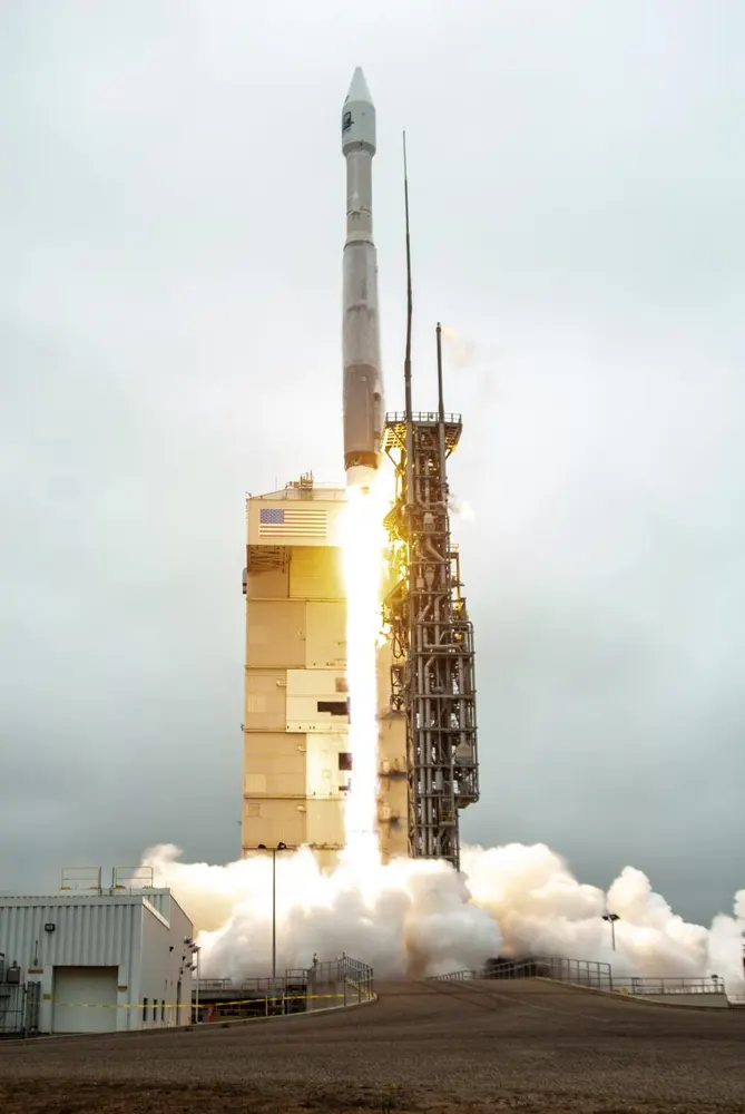Un razzo Atlas V che si solleva con una fiamma brillante e un fumo